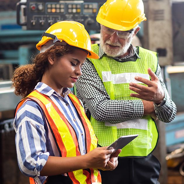 Older construction worker mentors younger one