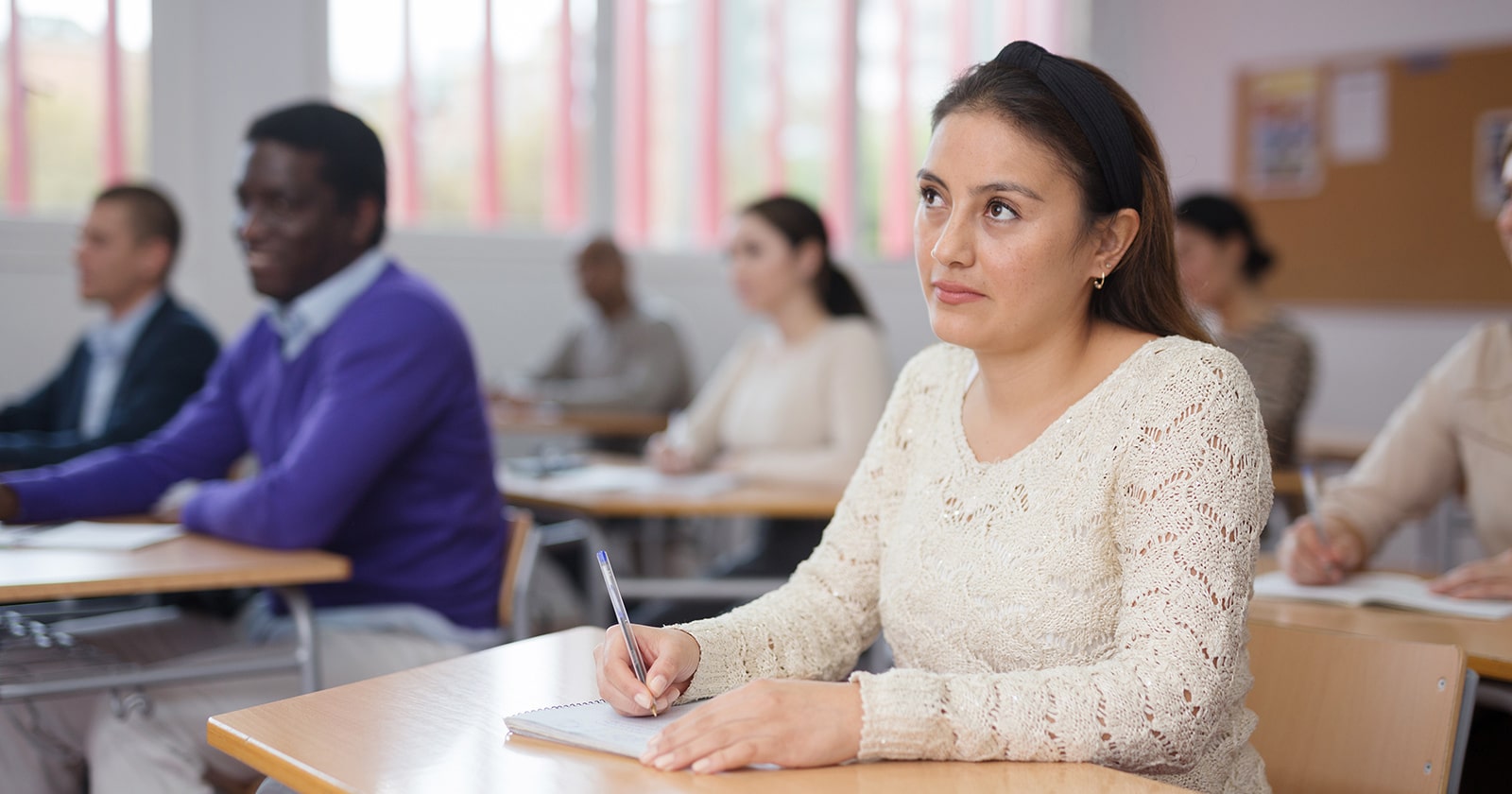 Hispanic woman listening to a lecture in a community college classroom