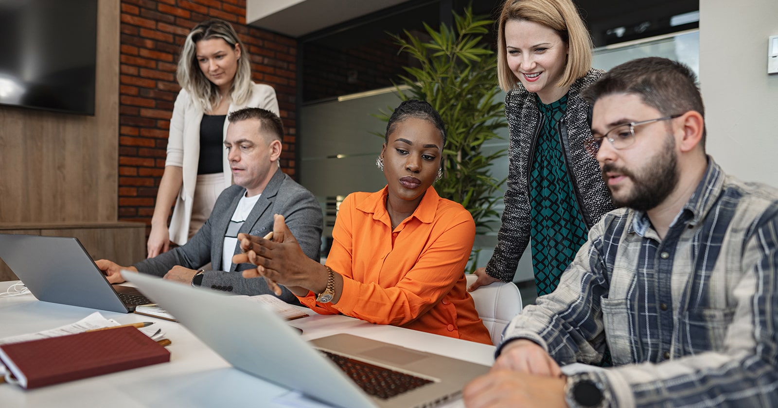 Diverse group of people collaborating around computers in an office