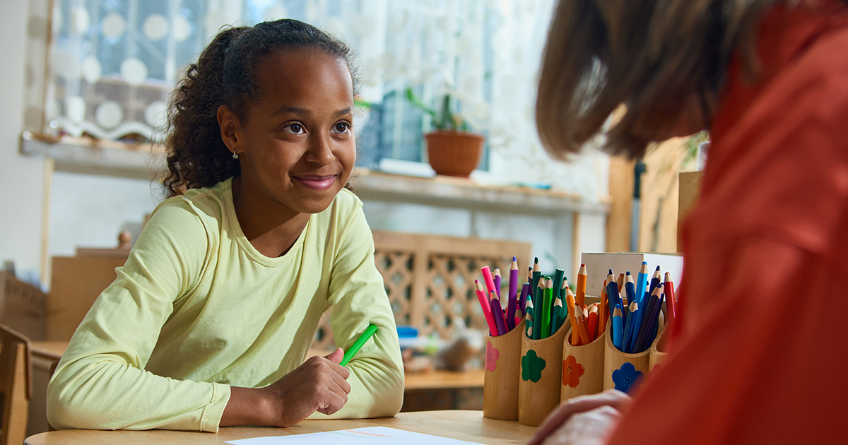 a woman is teaching a smiling middle school girl