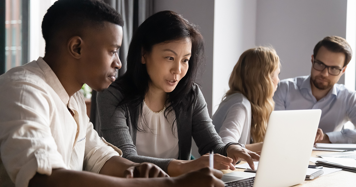 people are sitting in front of computers and collaborating.