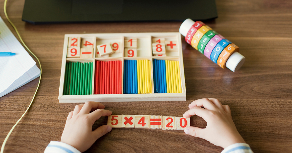 Hand's of boy arranging number blocks
