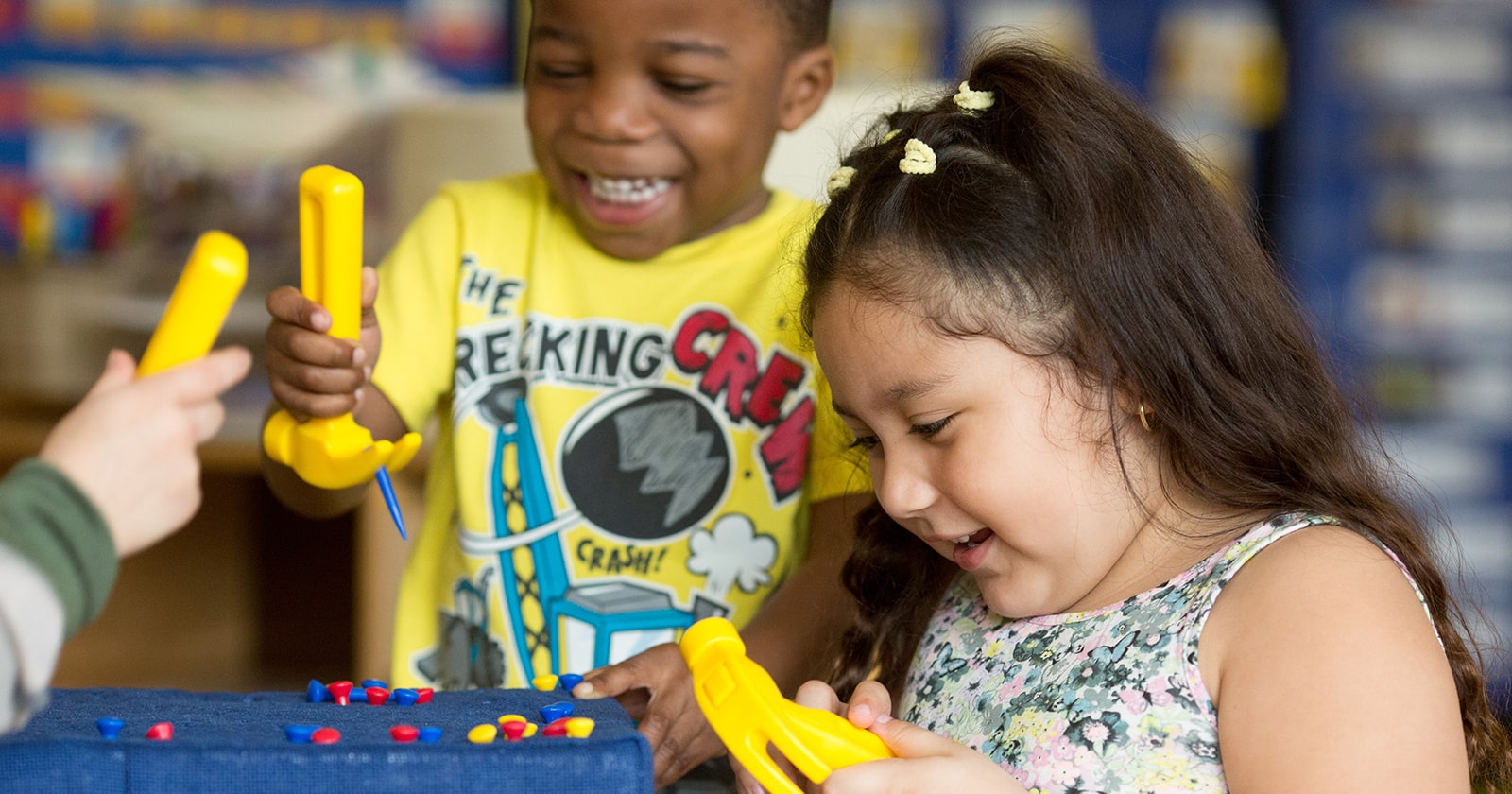Pre-K boy and girl playing with toy hammers at school