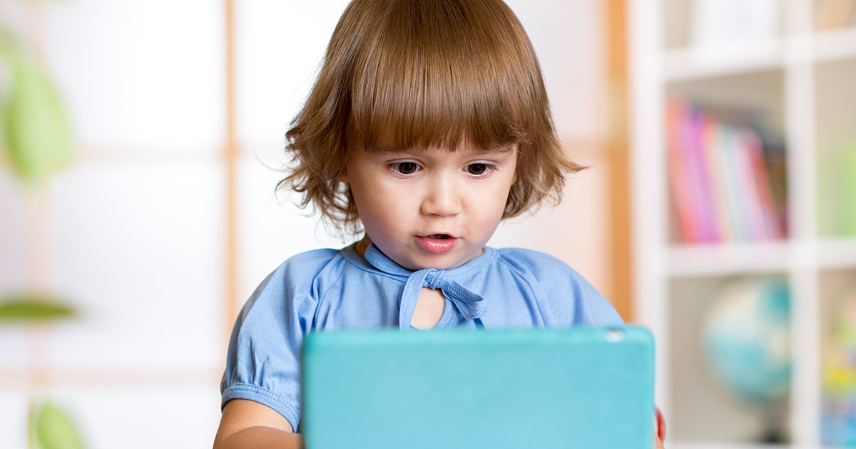 a little girl with a tablet in day care center.