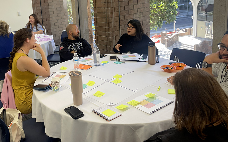 Colleagues sit at a round table strategizing