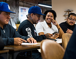 A consultant assists a small group of men in the Returning Citizens Stimulus Program
