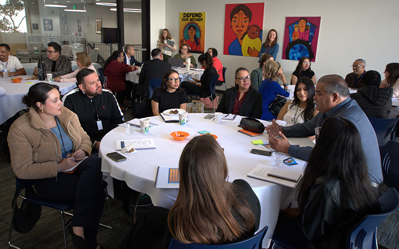 Participants at the BOOST conference sit at round tables and talk
