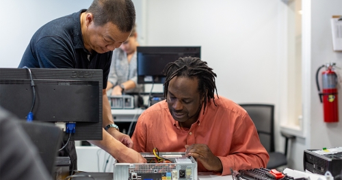 Two men working on computer hardware repair