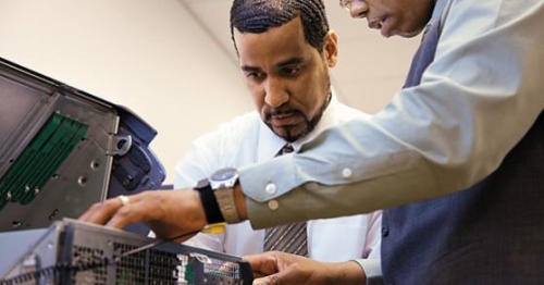 Two men working on computer hardware repair