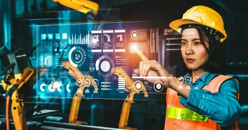 Woman in hard hat and high-visibility vest taps on a digital screen