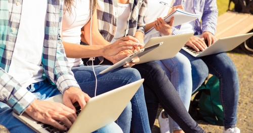 Hands of college students working on laptops