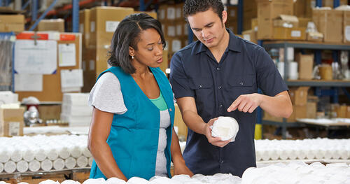 Two factory workers reviewing packing material