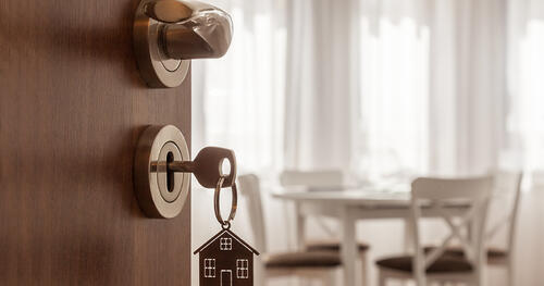 open door with a key in locker to a house