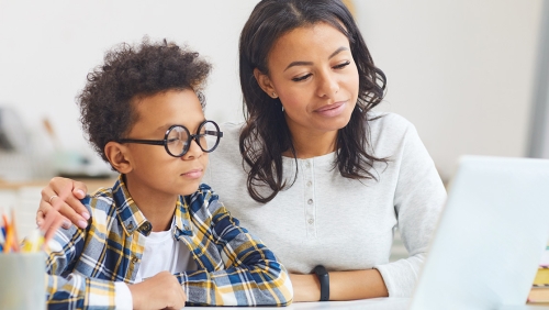 Female social worker helping child with his studies