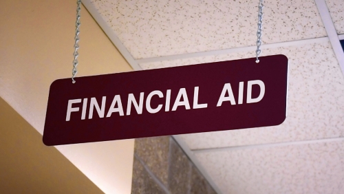 Sign that reads 'Financial Aid' hanging in a school building
