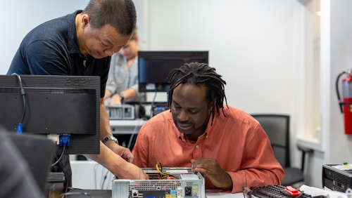 Two men working on computer hardware repair
