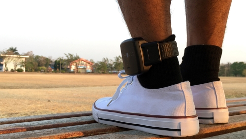 a man's feet with police braslet
