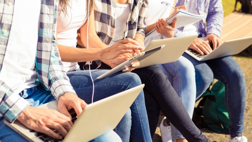 Hands of college students working on laptops