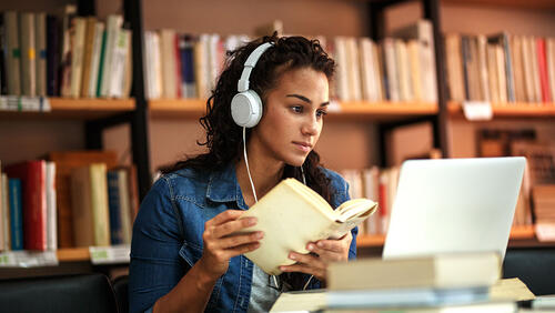 a femail is studying in a library