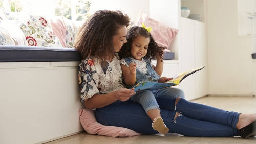 Mother reading a storybook to young daughter