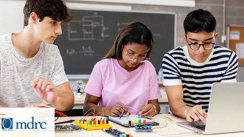 Three high school students work on a circuit board together