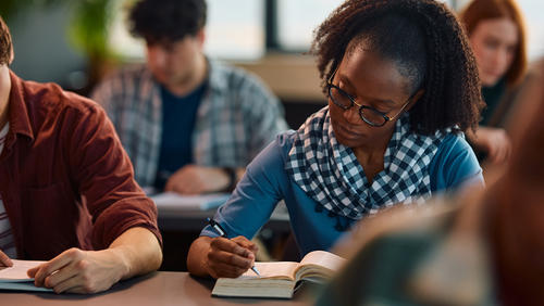 Diverse group of students taking notes in a college course