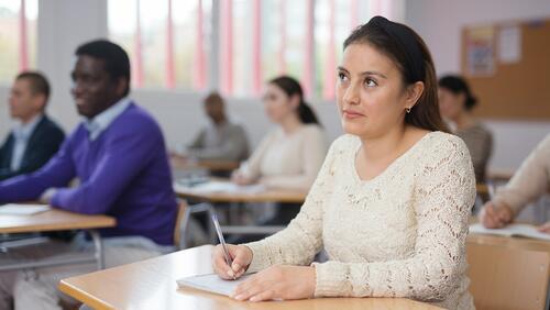 Hispanic woman listening to a lecture in a community college classroom