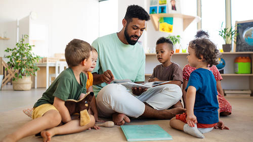 a man in a floor surraunded by kids