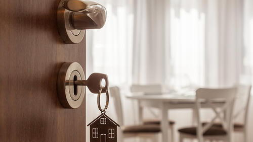 open door with a key in locker to a house