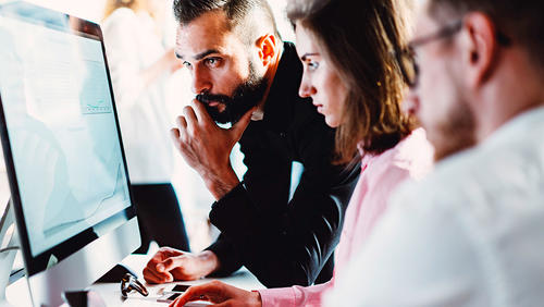 Colleagues reviewing information on a computer together