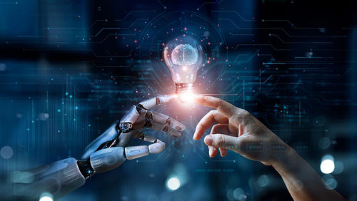 robot hand and human hand are holding a light bulb