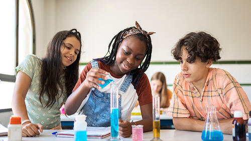 high school students doing an experiment during science class