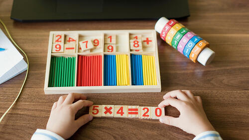 Hand's of boy arranging number blocks