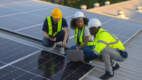 young engeneers install solar panels on roof