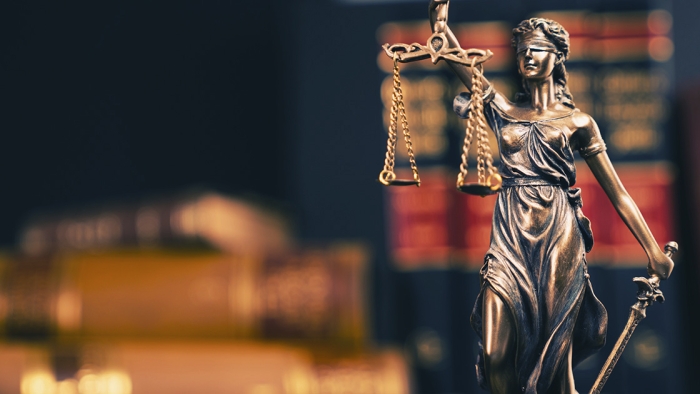 Lady justice statue in front of law books