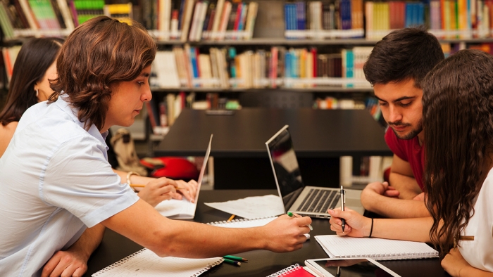 Group of college students working together at the library