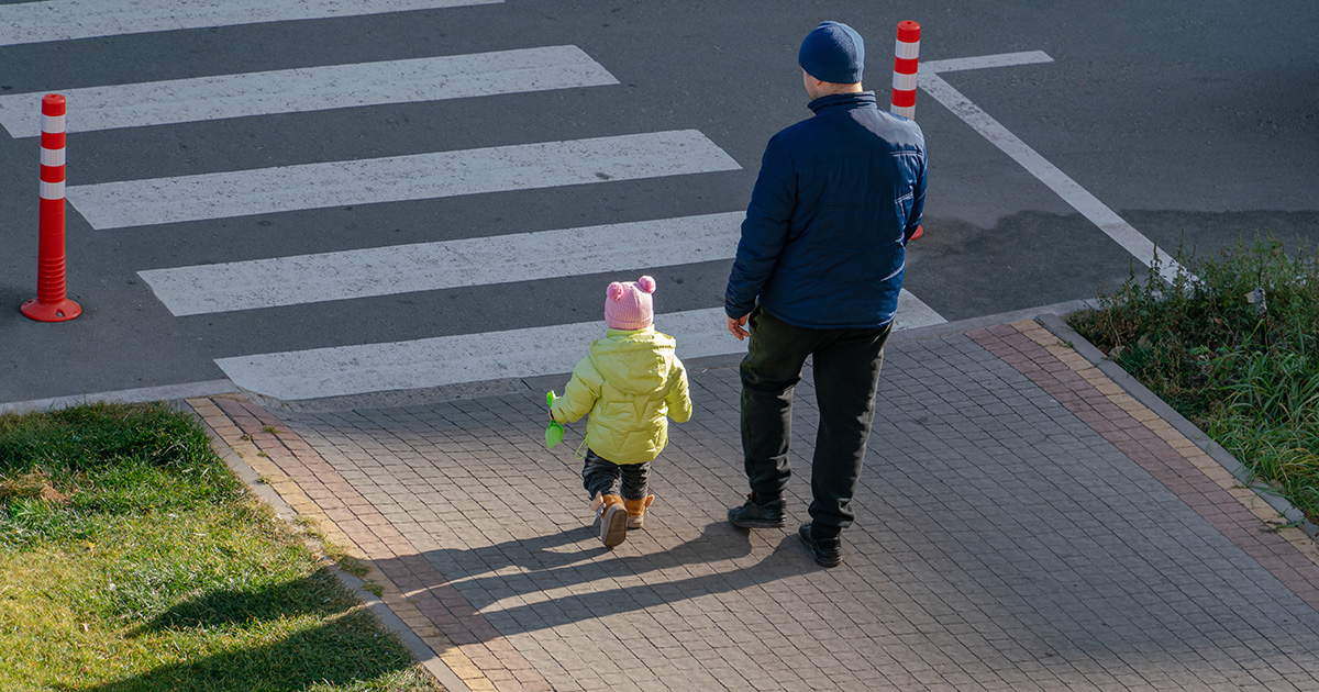 Father and child crossing the street together