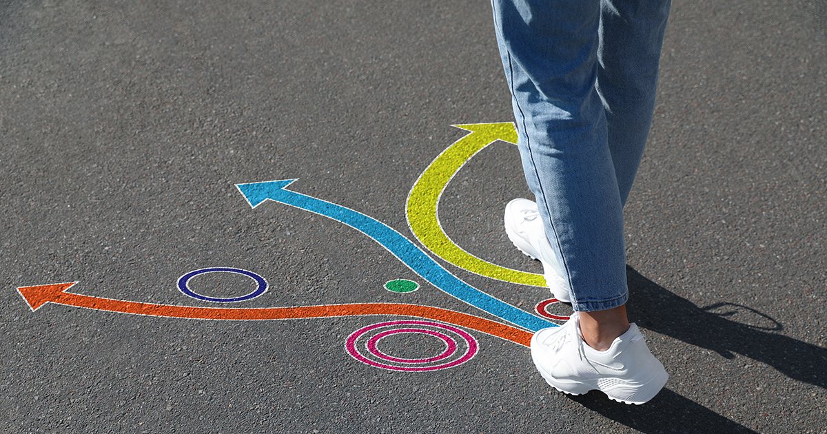 person's feet are standing in front of different paths 