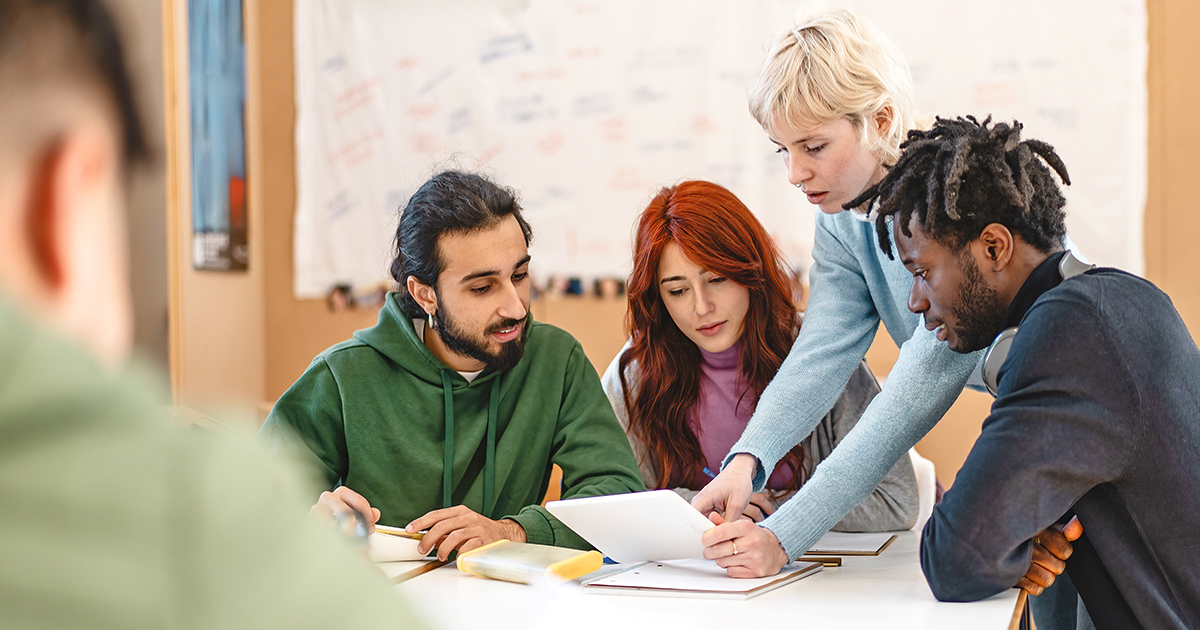 group of young people with a mentor are sitting around of table