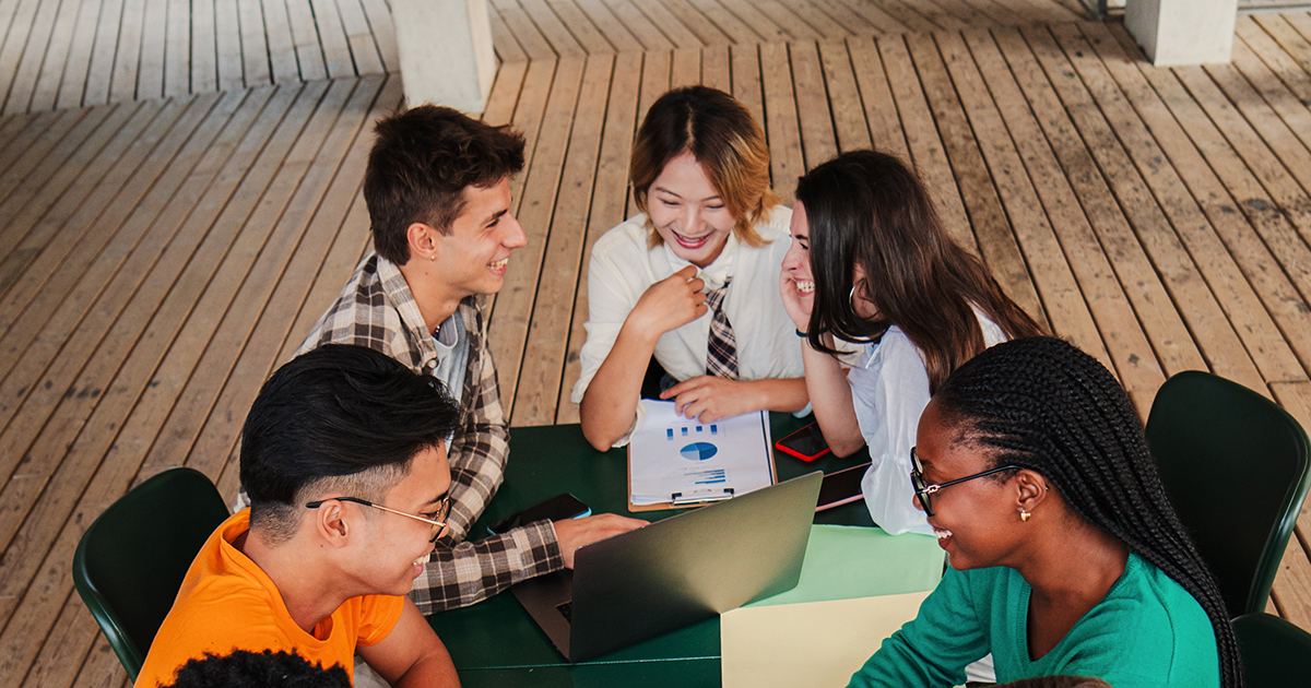 youth people are sitting around the table and discussing a project