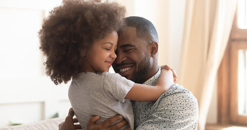 a father is holding and hugging his daughter