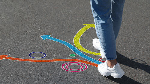 person's feet are standing in front of different paths 