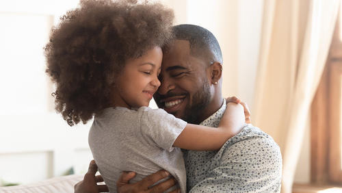 a father is holding and hugging his daughter