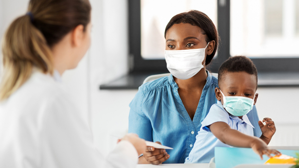 Black mother and child at pediatrician's office wearing masks